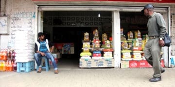 A spaza owner sits outside his supermarket in Kliptown, Soweto. Photo: Nhlanhla Phillips